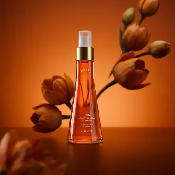 Perfume em um cenário alaranjado com elementos florais